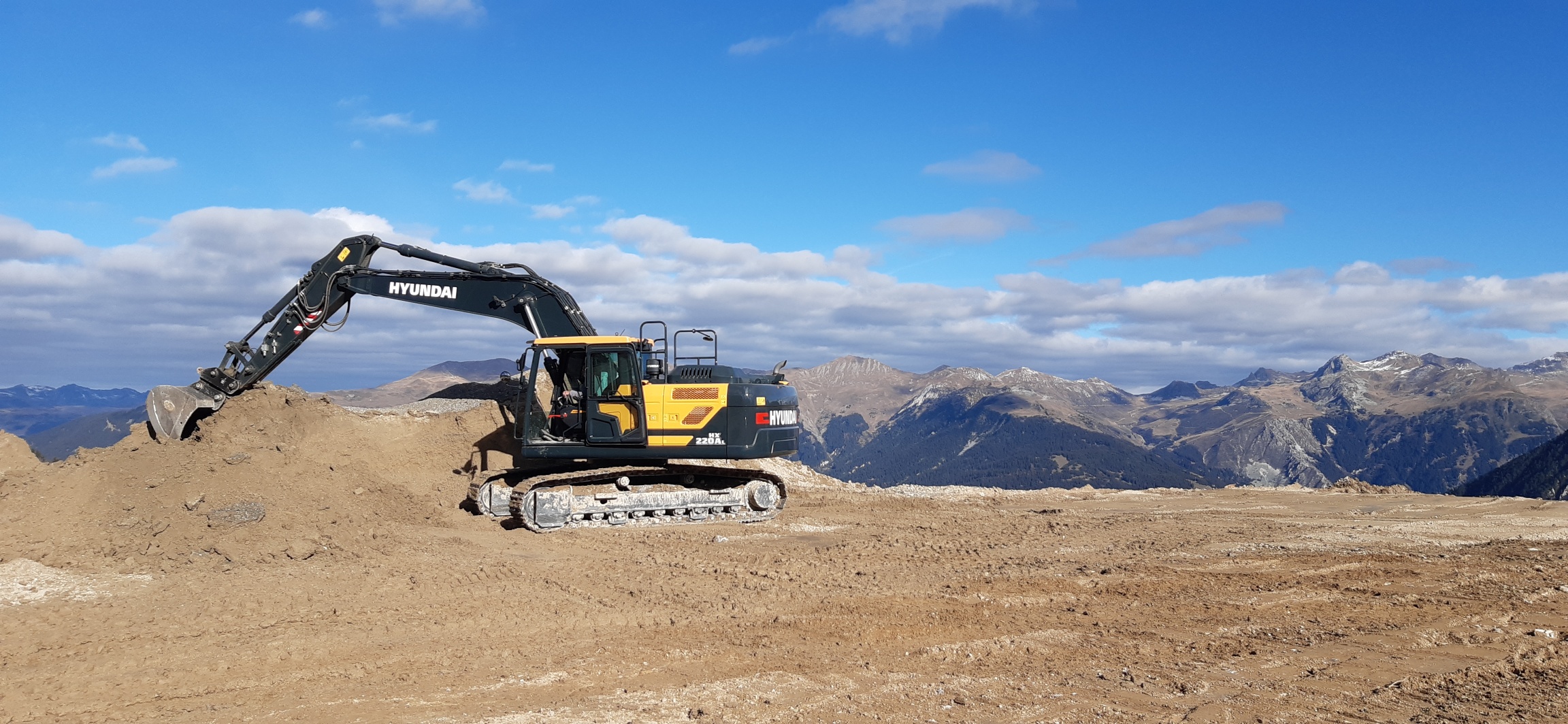 De HX220AL wordt aangedreven door een robuuste Stage V-gecertificeerde Cummins- motor met een innovatief, geïntegreerd uitlaatgasnabehandelingssysteem dat zowel de emissies als de onderhoudsvereisten vermindert. Deze levert al het vermogen dat u nodig hebt om zware werkzaamheden uit te voeren, samen met snelle nivellerings- en laadtijden van vrachtwagens en een uitstekend brandstofverbruik. Er is een reeks slimme technologieën opgenomen voor een nauwkeurig beheer van het motorvermogen en het pompdebiet. Een nieuw EPFC-systeem (Electronic Pump Flow Control) verbetert de beheersbaarheid en verlaagt de bedrijfskosten. Extra besturings- en bewakingsfuncties helpen u uw productiviteit elke dag verder te verbeteren.